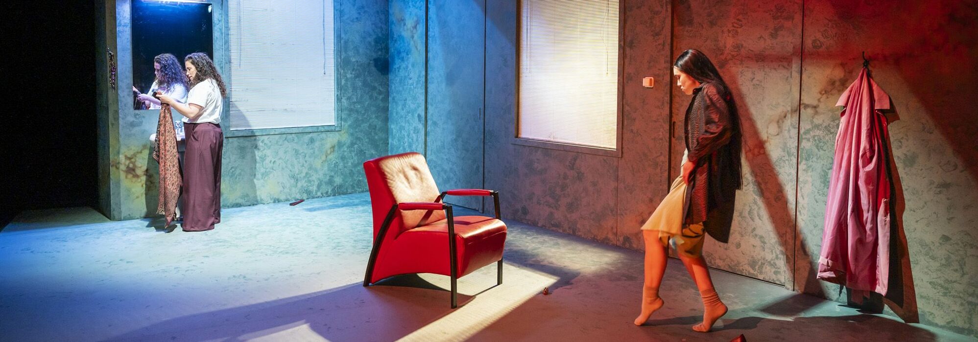 Afbeelding van de voorstelling: Een portret van een vrouw met lang, krullend haar is verdeeld in twee helften: de linkerzijde is een zwart-witfoto, de rechterzijde is kleurrijk bewerkt met felle patronen, lijnen en grafische elementen op een turquoise achtergrond.