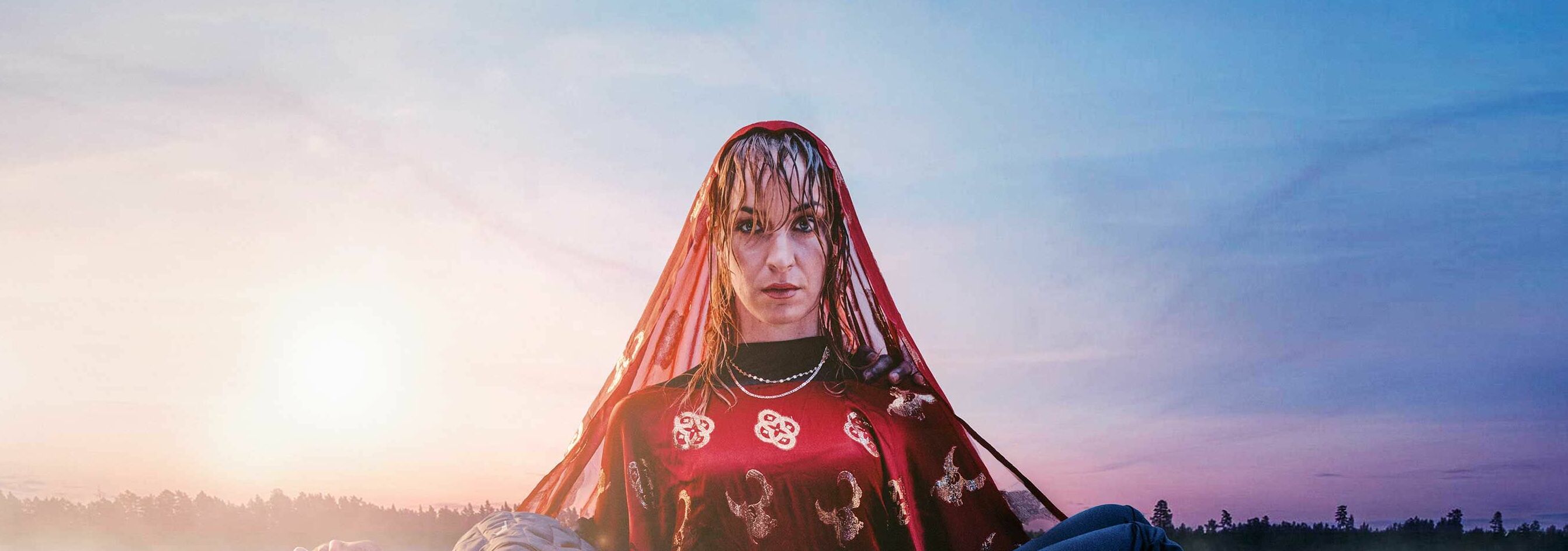 Afbeelding van de voorstelling: Twee personen in donkere kleding en gezichtsmaskers, die in een mysterieuze en schemerige omgeving staan.